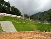 A grassy hill with a fence and a hill

AI-generated content may be incorrect.